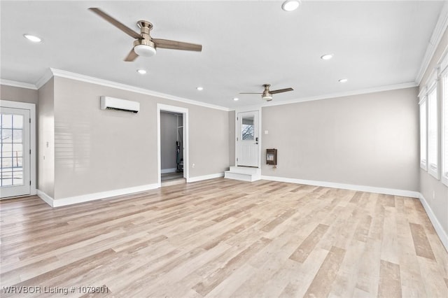 unfurnished living room featuring ornamental molding, a ceiling fan, a wall mounted AC, light wood-style floors, and baseboards