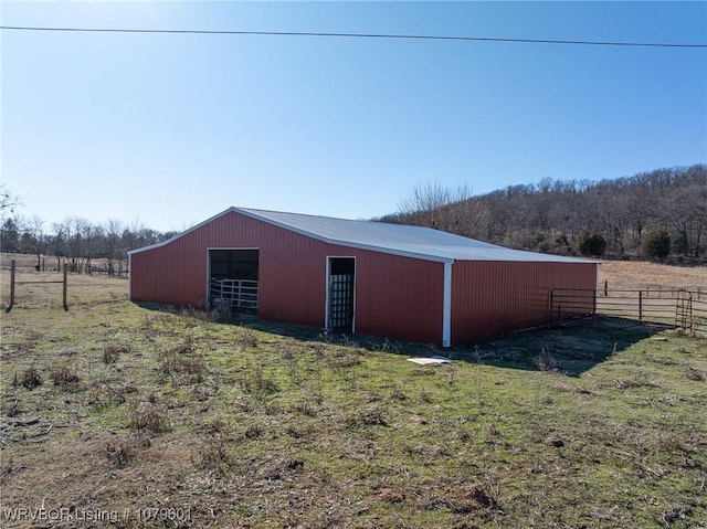 view of pole building featuring a rural view and fence