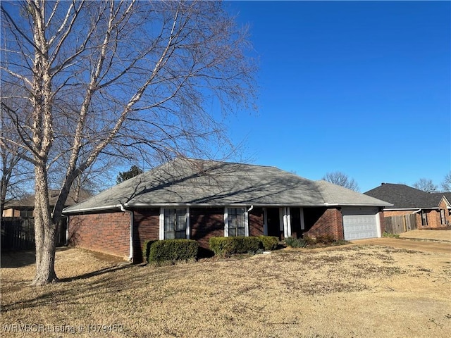 single story home with a garage, driveway, fence, and brick siding