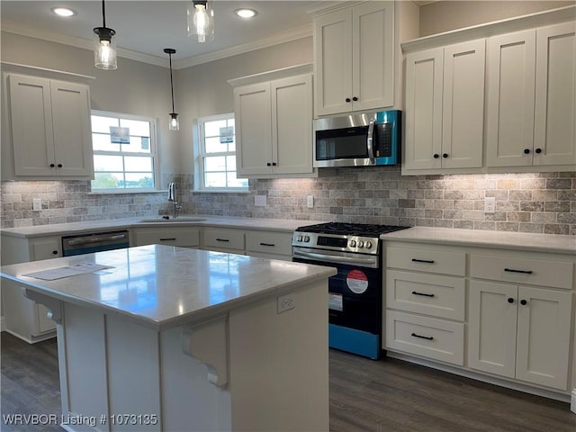 kitchen featuring pendant lighting, a center island, sink, white cabinetry, and stainless steel appliances