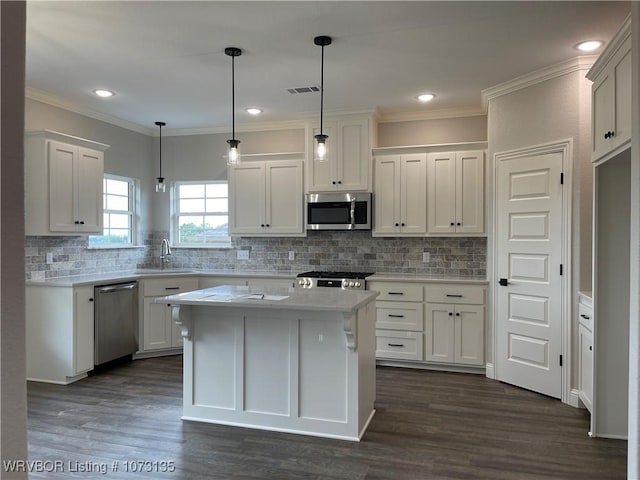 kitchen featuring sink, stainless steel appliances, dark hardwood / wood-style flooring, pendant lighting, and white cabinets