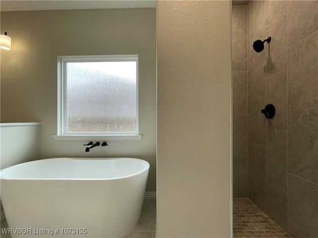 bathroom featuring plenty of natural light and independent shower and bath