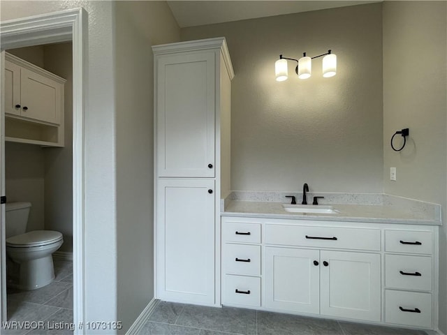 bathroom featuring tile patterned flooring, vanity, and toilet