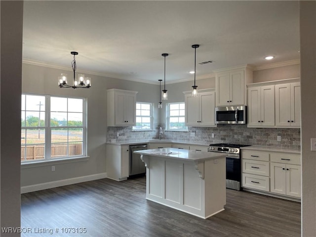 kitchen with pendant lighting, a center island, white cabinets, sink, and stainless steel appliances