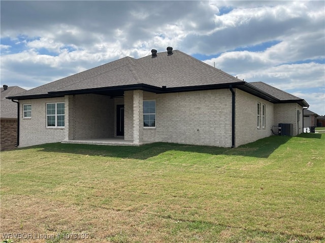 rear view of property with a yard, central AC unit, and a patio area