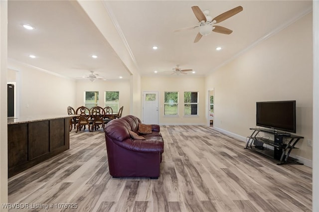 living room with light hardwood / wood-style floors, ornamental molding, and a wealth of natural light