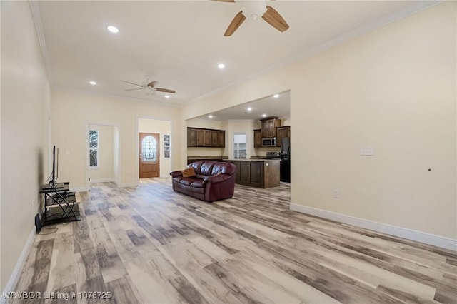 living room with crown molding, ceiling fan, and light hardwood / wood-style floors