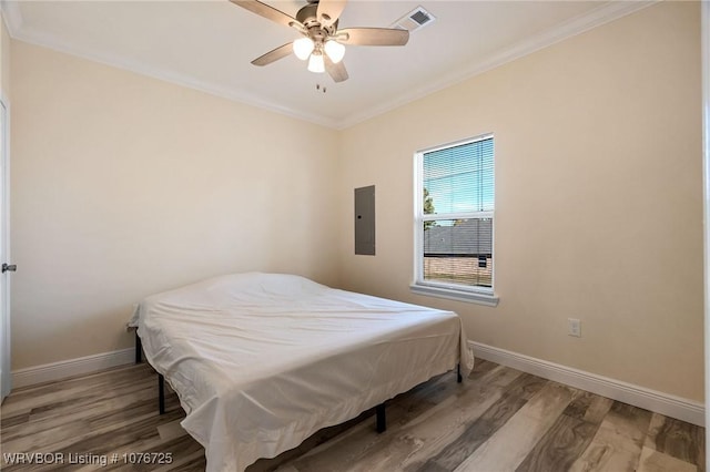 bedroom featuring hardwood / wood-style floors, electric panel, ceiling fan, and ornamental molding