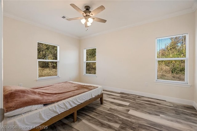 bedroom with hardwood / wood-style flooring, ceiling fan, and ornamental molding