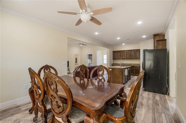 dining room with light hardwood / wood-style flooring, ceiling fan, ornamental molding, and sink