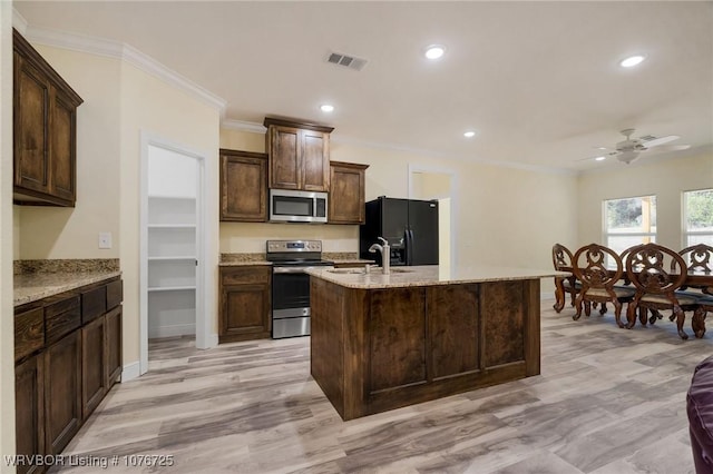 kitchen with a center island with sink, crown molding, ceiling fan, dark brown cabinetry, and stainless steel appliances