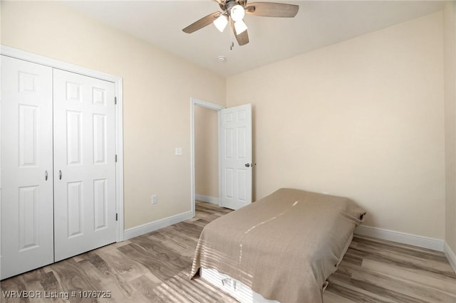 bedroom with ceiling fan, light hardwood / wood-style floors, and a closet