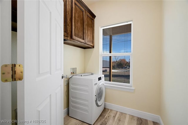 laundry area with cabinets, light hardwood / wood-style floors, and washer / dryer