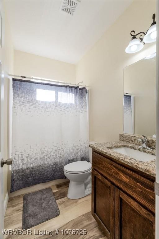 bathroom featuring hardwood / wood-style flooring, vanity, and toilet