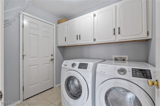 laundry area featuring cabinet space, independent washer and dryer, and light tile patterned floors