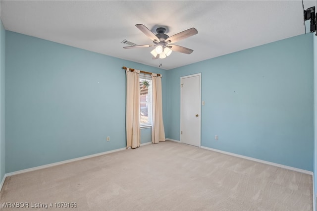 unfurnished room with a ceiling fan, visible vents, light carpet, and baseboards