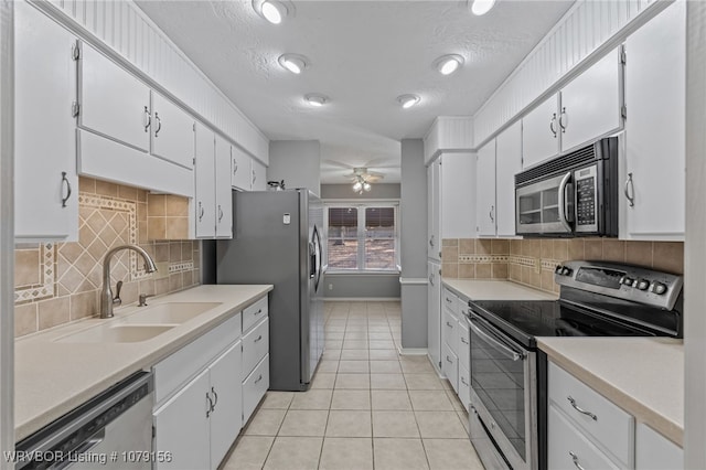 kitchen with appliances with stainless steel finishes, white cabinets, and light countertops