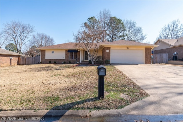 ranch-style home with an attached garage, fence, concrete driveway, and brick siding