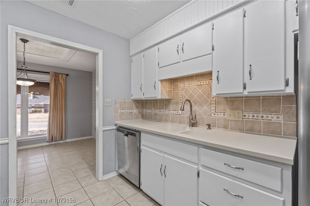 kitchen featuring a sink, white cabinetry, light countertops, stainless steel dishwasher, and pendant lighting