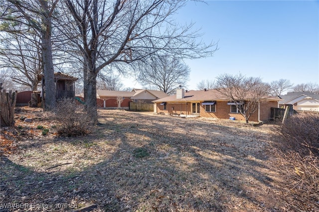 exterior space featuring a chimney and fence