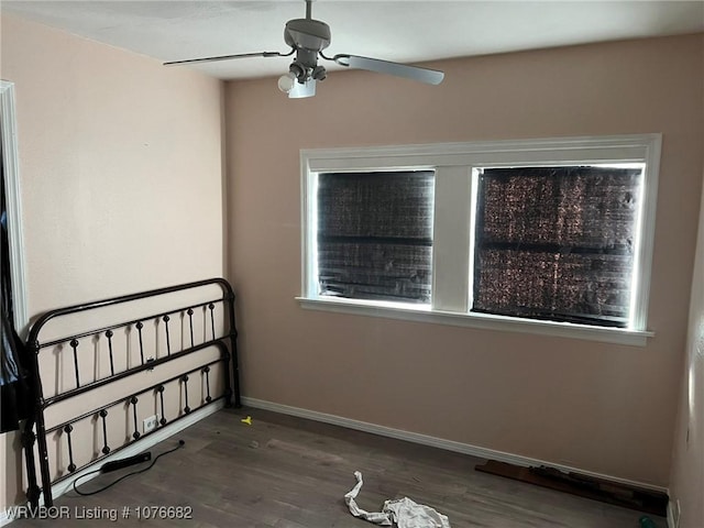 empty room with ceiling fan and dark hardwood / wood-style floors