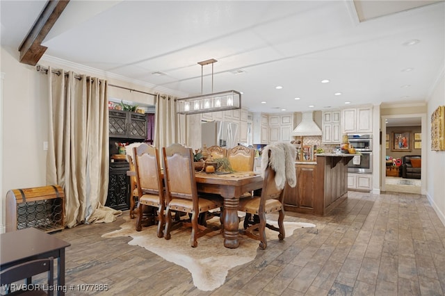 dining area featuring light wood-type flooring and crown molding