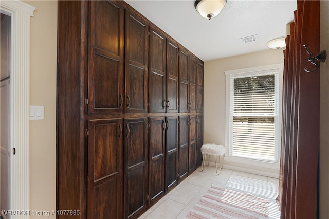 mudroom with a healthy amount of sunlight and light tile patterned flooring