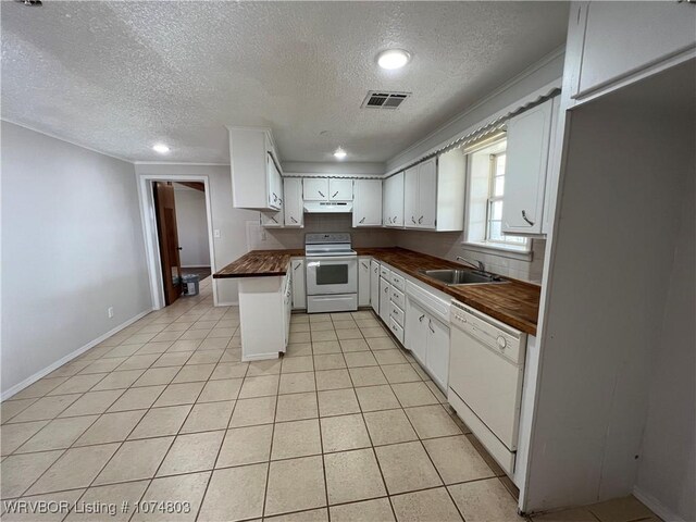 kitchen featuring butcher block counters, white cabinetry, sink, a textured ceiling, and white appliances