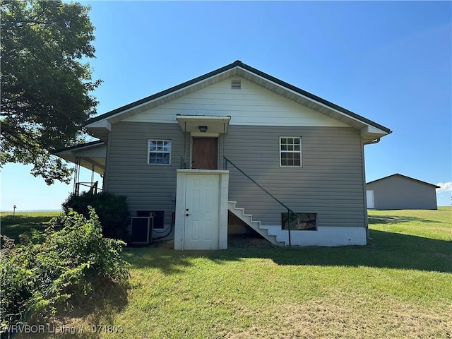 rear view of house with a lawn and central AC