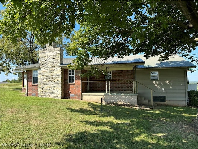 rear view of house featuring a yard