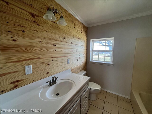 bathroom featuring vanity, crown molding, tile patterned flooring, toilet, and wood walls