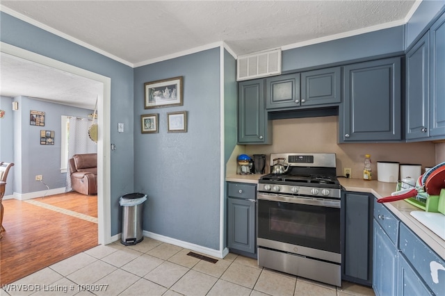 4209 Old Jenny Lind Rd, Fort Smith, AR 72901 - kitchen featuring gas range, light countertops, light tile patterned floors, ornamental molding, and a textured ceiling