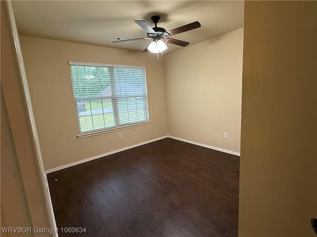 spare room with ceiling fan, baseboards, and dark wood finished floors
