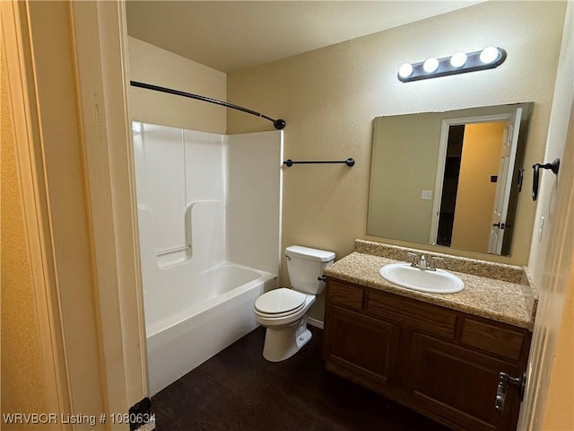 full bathroom with toilet, wood finished floors, shower / washtub combination, baseboards, and vanity