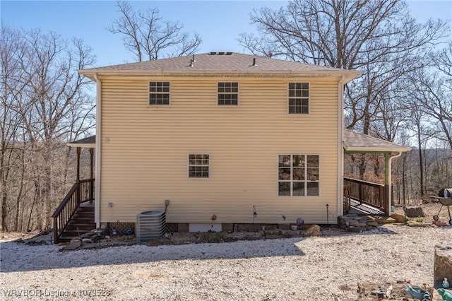 back of property featuring central air condition unit and roof with shingles