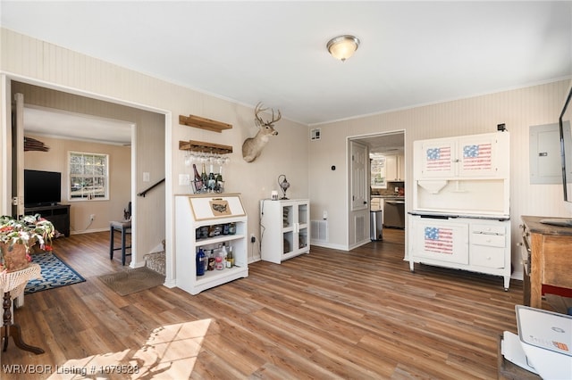 kitchen with ornamental molding, wood finished floors, baseboards, and stainless steel dishwasher