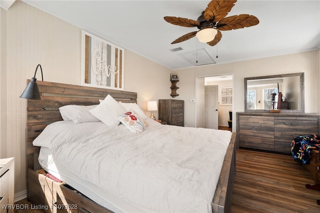 bedroom with wood finished floors, visible vents, attic access, ceiling fan, and ornamental molding