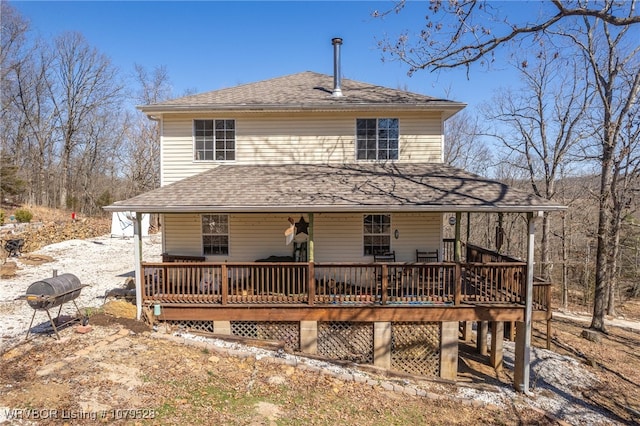 rear view of house featuring a deck and a shingled roof