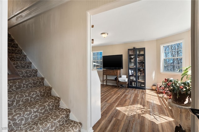 staircase featuring baseboards and wood finished floors