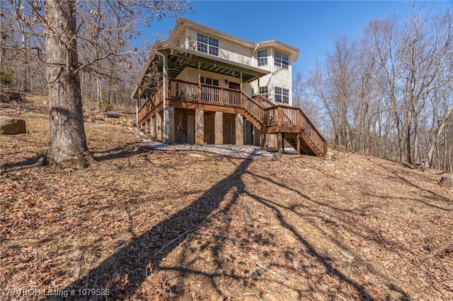 back of house with a porch and stairway