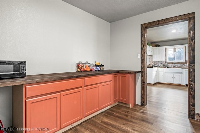 kitchen with decorative backsplash, a textured ceiling, dark hardwood / wood-style floors, and sink