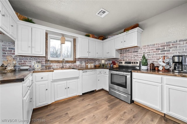 kitchen featuring stainless steel electric stove, dishwasher, white cabinets, and sink