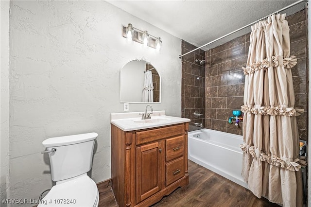 full bathroom featuring hardwood / wood-style floors, a textured ceiling, toilet, shower / bath combo with shower curtain, and vanity