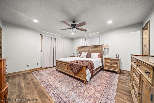 bedroom with a textured ceiling, dark hardwood / wood-style floors, and ceiling fan