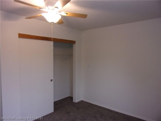 unfurnished bedroom featuring ceiling fan, dark carpet, and a closet