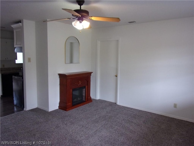 unfurnished living room with ceiling fan and dark carpet