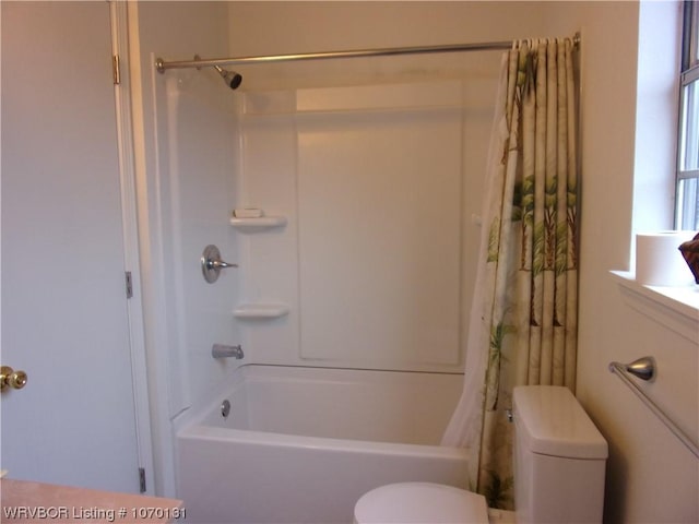 bathroom featuring toilet and shower / bath combo with shower curtain