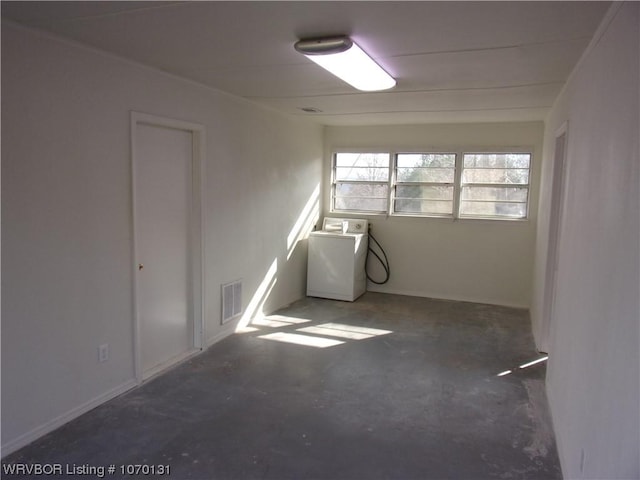 spare room featuring concrete flooring and washer / dryer