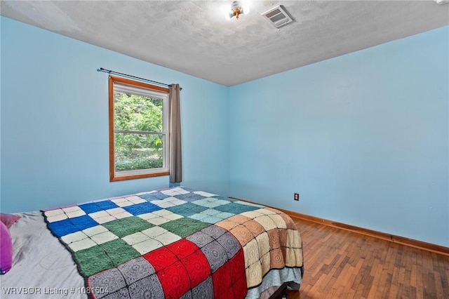 1310 Pigeon Creek Rd, Mountainburg, AR 72946 - unfurnished bedroom with hardwood / wood-style flooring and a textured ceiling