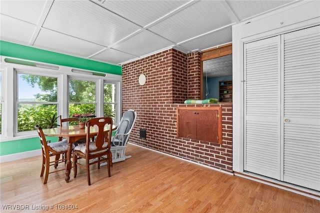 1310 Pigeon Creek Rd, Mountainburg, AR 72946 - dining area with brick wall and light wood-style flooring